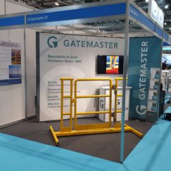 Exhibition stand with yellow offshore railing hardware. Sign with Gatemaster in background